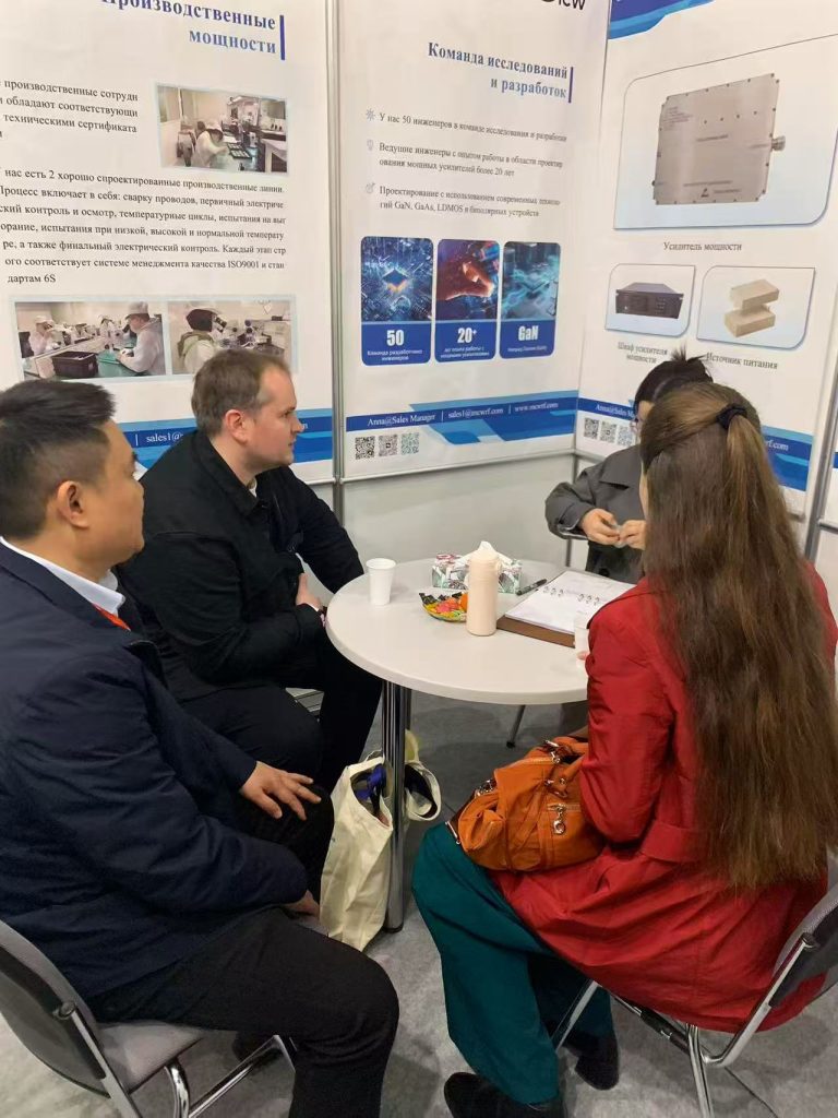 Mcw engineers discussing RF technology and quality control with exhibition visitors